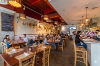 Salumeria 104 Midtown Miami dining room with exposed brick and warm Edison lighting